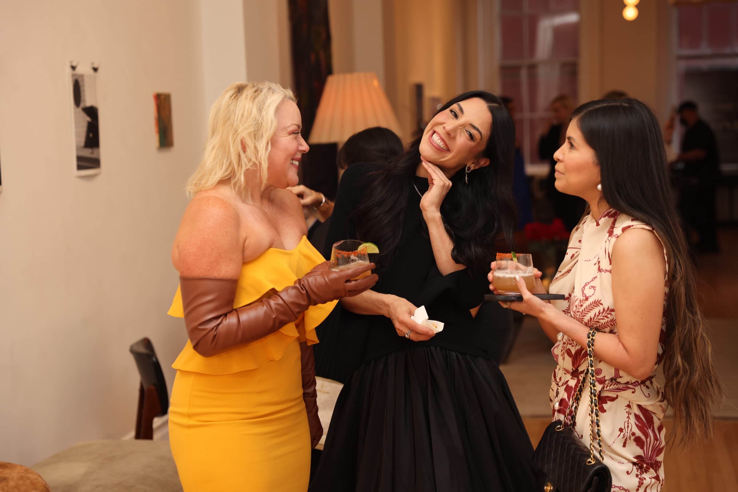 Three guests laughing with drinks